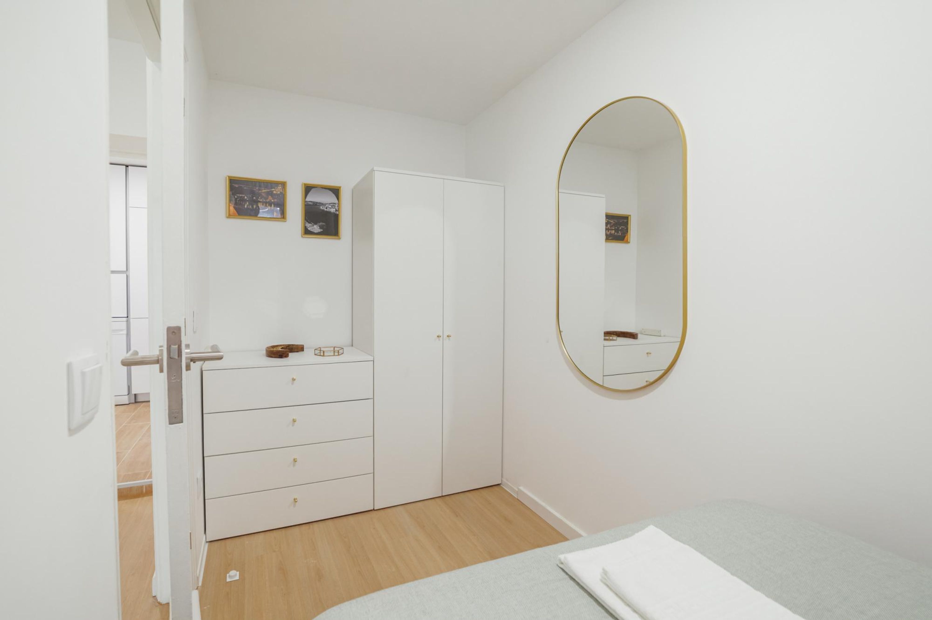 Een slaapkamer met een bed, een kledingkast, een dressoir en een spiegel.