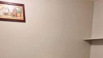 Une petite salle de bain avec des toilettes, un meuble blanc et un plancher en bois.