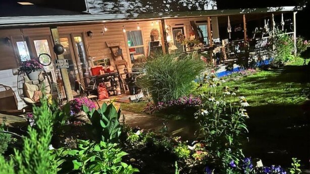 Una casa de madera bien iluminada con jardín delantero.