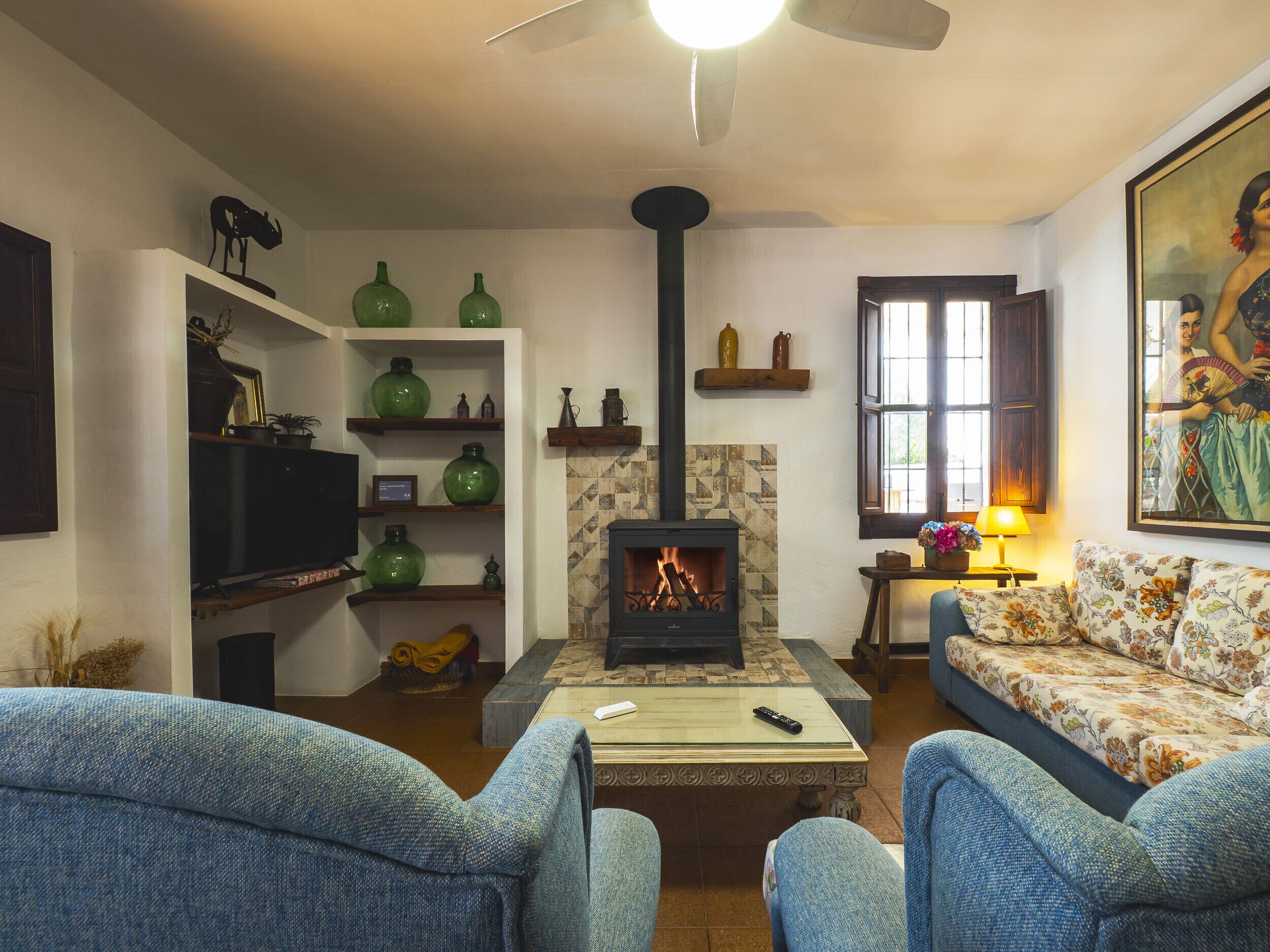 A living room with a fireplace, green vases, a sofa, and a television.