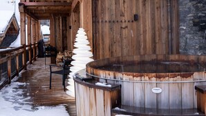 Une construction en bois dotée d’un bain à remous et d’une terrasse en bois.