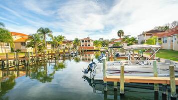 A marina with boats docked, surrounded by residential buildings and palm trees.