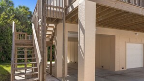 A building under construction with exposed wooden beams and a concrete foundation. - Brand new August 2023 3 BR, 2 BA Tarpon on stilts (Homosassa)