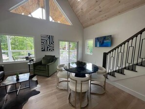Relax in this spacious living area with a central table, comfortable seating, and a staircase.