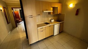 A compact kitchen with wooden cabinets, a sink, a dishwasher, and a toaster. - Cozy poolside apartment with 5 beds (San Pawl il-Baħar)