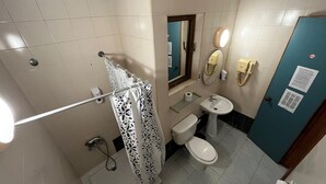 A bathroom with a shower, toilet, sink, and a mirror. - Cozy poolside apartment with 5 beds (San Pawl il-Baħar)