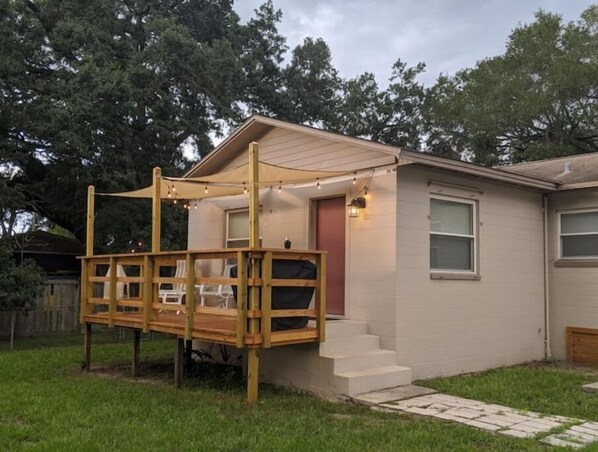 A single-story house with a covered patio area, a front door, and a small set of steps leading to the entrance.