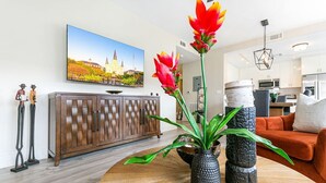 Un salon moderne avec un meuble en bois, une table basse ronde et un grand tableau représentant un château.