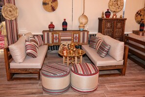 Un salon de style traditionnel, comprenant un canapé, des poufs et une table basse.