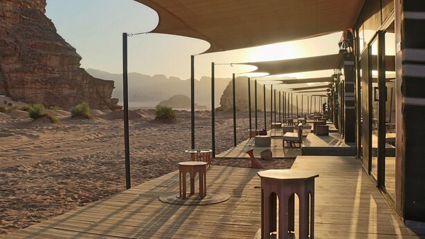 A desert resort with outdoor seating under a canopy, overlooking a rocky landscape. - Rum Imagination Luxury Camp (Wadi Rum)