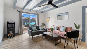 A modern living room with a grey sofa, a pink sofa, a coffee table, and a TV stand. - Outdoor Bar/Jacuzzi/Ocean & Bay Breeze Hideaway (Chula Vista)