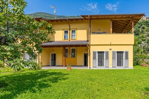 A two-story yellow building with a flat roof, large windows, and a covered patio area. - Casa Veligato 2, San Siro, Italy (San Siro)