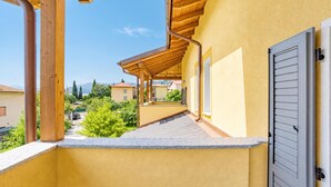 A balcony with a wooden pergola, a grey door, and a view of the neighborhood. - Casa Veligato 2, San Siro, Italy (San Siro)