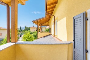 A balcony with a wooden pergola, a grey door, and a view of the neighborhood. - Casa Veligato 2, San Siro, Italy (San Siro)