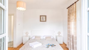 A neatly arranged bedroom with a bed, bedside tables, a hanging light fixture, and a framed picture on the wall. - Casa Veligato 2, San Siro, Italy (San Siro)