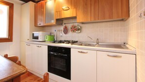 A kitchen with wooden cabinets, a microwave, a gas stove, and a dishwasher.