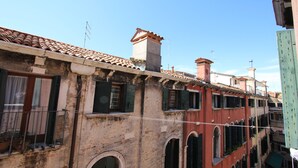 Une rangée de bâtiments à l’architecture traditionnelle, avec notamment des fenêtres en arc et des toits couverts de tuiles.