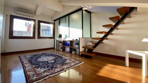A spacious room with a wooden staircase, large windows, and a patterned rug. - Apartment Altana, Amazing Grand Canal View (Venecia)