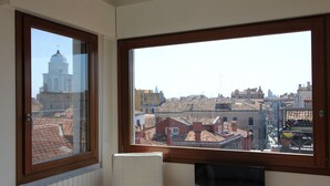 A room with a large window overlooking a cityscape with historical buildings and a church. - Apartment Altana, Amazing Grand Canal View (Venecia)