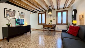 A living room with a TV, dining table, and sofa. - San Giovanni (Venice Historical Centre) (Venecia)