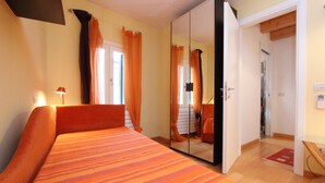 Une chambre à coucher avec un lit, une armoire et un miroir.