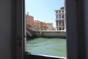 Vista desde el interior de un edificio hacia un canal bordeado de edificios.