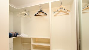 A walk-in closet with multiple shelves and hanging space.