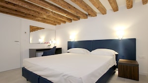 Een slaapkamer met een bed, een bureau en een stoel.