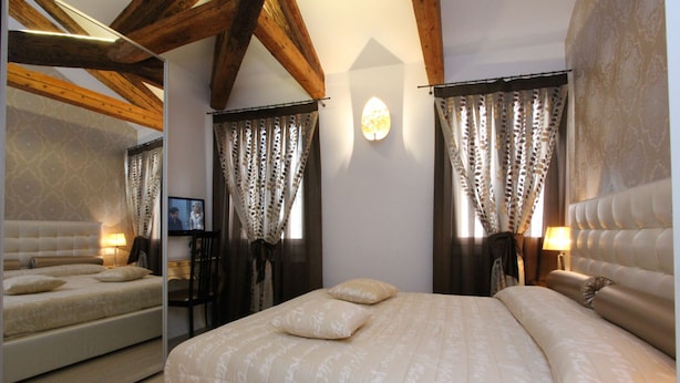 A bedroom with a large bed, a mirror, and a television. - Apt. Gold Design (300m from Rialto´s Bridge) (Venecia)