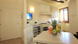 A kitchen with white cabinets, a stove, and a fruit bowl on the counter. - Venice Amazing View (St. Mark´s Square 700m) (Venecia)