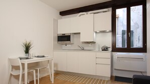 A compact kitchen with white cabinets, a microwave, and a window with a view of the outside. - Rialto Studio (300mt from Rialto´s Bridge) (Venecia)