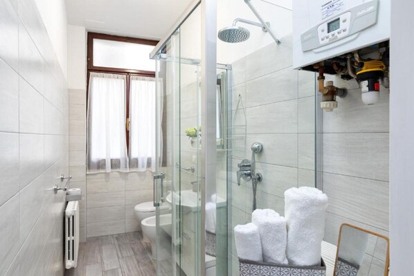 Une salle de bain moderne avec une douche à l’italienne, des toilettes et un lavabo.