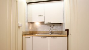 A compact kitchen with a sink, cabinets, and a backsplash. - San Marco Gallery (80m from St Mark´s Square) (Venecia)