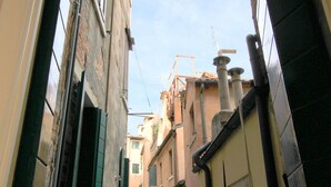 A narrow alleyway between buildings with visible pipes and antennas. - San Marco Gallery (80m from St Mark´s Square) (Venecia)