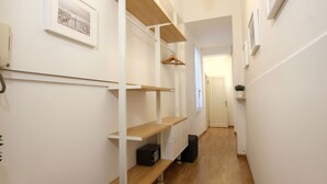 A narrow hallway with white walls, wooden flooring, and built-in shelving units with a coat rack. - San Marco Gallery (80m from St Mark´s Square) (Venecia)