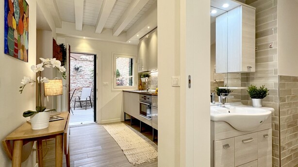 A modern kitchen with stainless steel appliances, a large window, and a view of the backyard. - Acquamarina Terrace (Historical Center) (Venecia)