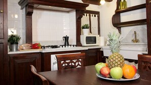 A kitchen with wooden cabinets, a microwave, and a fruit bowl on the counter. - Apartment Marin Venetian Style (Venecia)