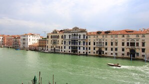 A canal with buildings along the banks and a boat moving through the water. - Apartment Grand Canal View (with lift) (Venecia)