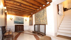 A spacious lobby with a wooden ceiling, a large painting, a staircase, and a patterned rug. - San Marco Central (100m from St Mark's Square) (Venecia)