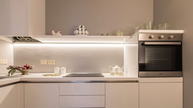 A modern kitchen with a built-in oven, a sink, and a countertop with decorative items. - San Marco Central (100m from St Mark's Square) (Venecia)