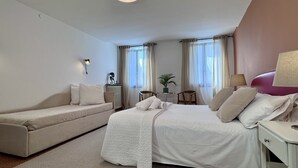 A hotel room with a bed, a sofa, a small table with a plant, and a lamp. - Apt. Fosca Canal View (Venecia)
