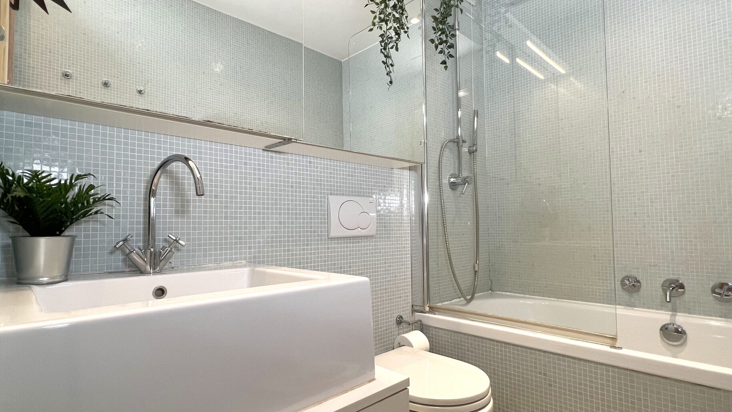 Ein modernes Badezimmer mit einer großen weißen Badewanne, einer separaten Duschkabine und einem WC.