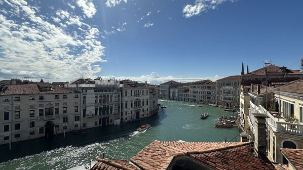 A canal with historic buildings, boats, and a clear sky. - Grand Canal Loft Terrace (Venecia)