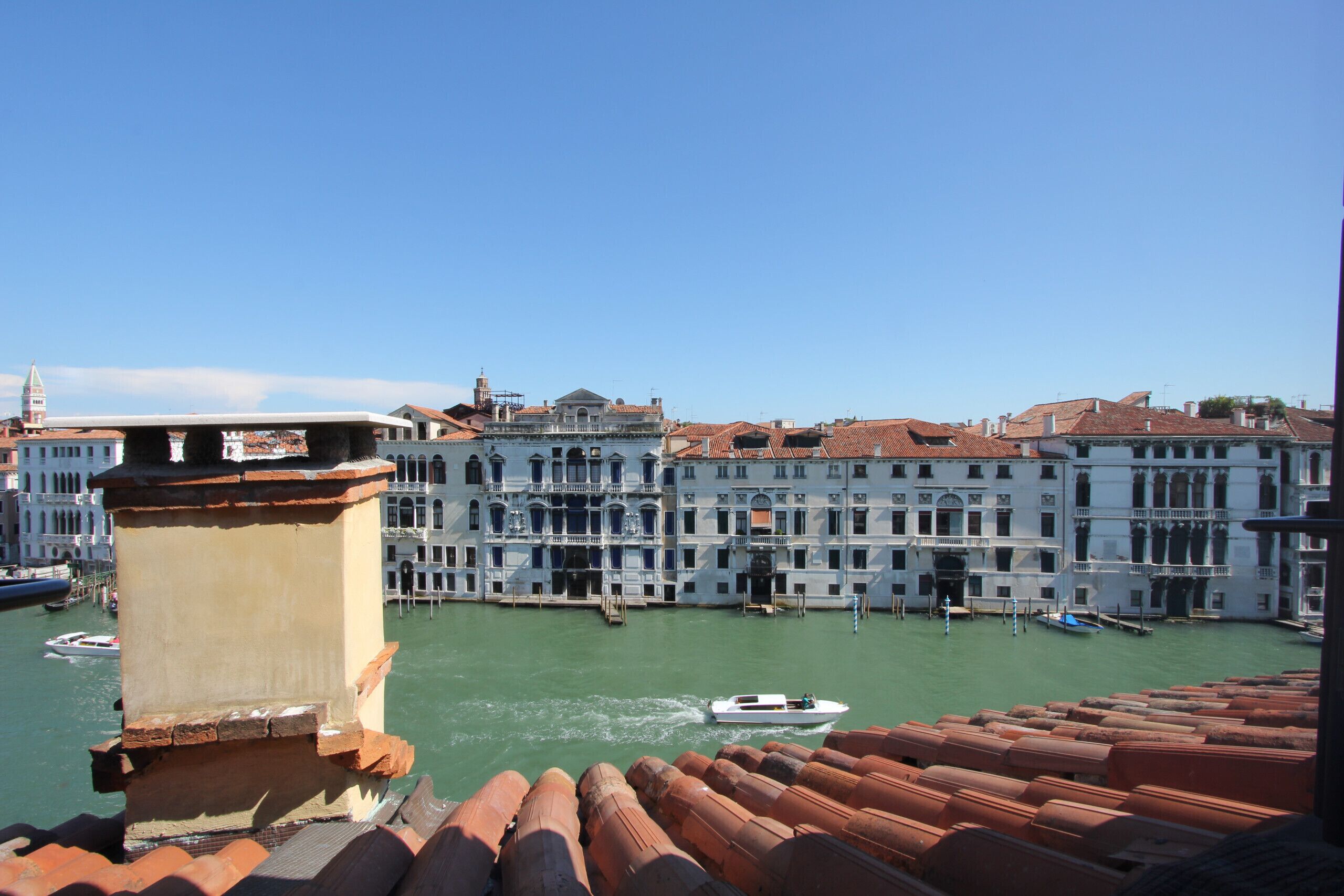 Un canale fiancheggiato da edifici, una barca sull'acqua e un ponte sullo sfondo.