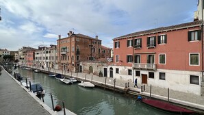 Un canal con barcos, edificios históricos y una pasarela peatonal.