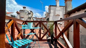 A rooftop terrace with a wooden railing, a blue folding chair, and a potted plant. - Relax Terrace (Venice Historical Center) (Venecia)