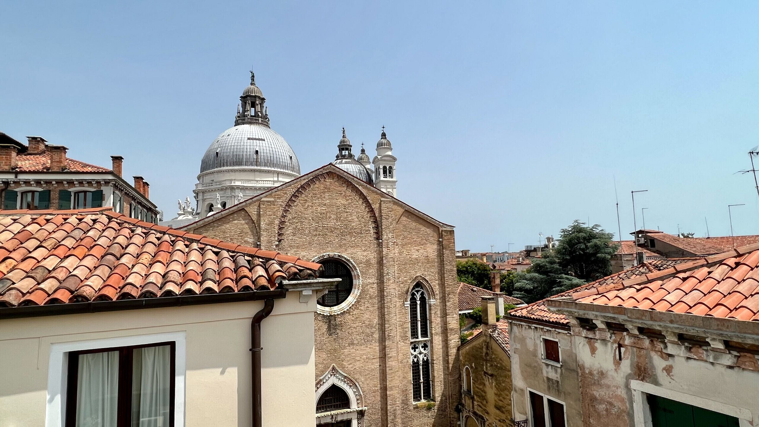 A building with a tiled roof, a dome, and a bell tower.