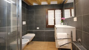 A modern bathroom with a glass shower enclosure, a toilet, a bidet, and a vanity with a towel rack. - Apt. Ca'Puccetti Bis (350mt from Rialto's Bridge) (Venecia)