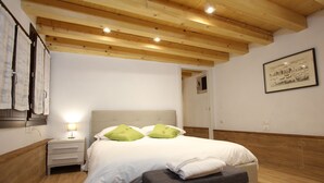 A bedroom with a wooden ceiling, a bed with white bedding and green pillows, a bedside table, and a small window. - Apt. Ca'Puccetti Bis (350mt from Rialto's Bridge) (Venecia)