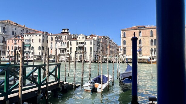 A canal with boats, wooden walkways, and historic buildings with arched windows and balconies. - Gondola Grand Canal (Historical Center) (Venecia)